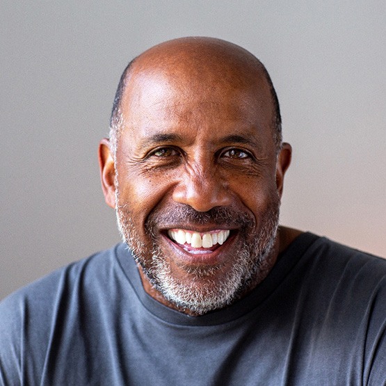 Senior man smiling in gray shirt