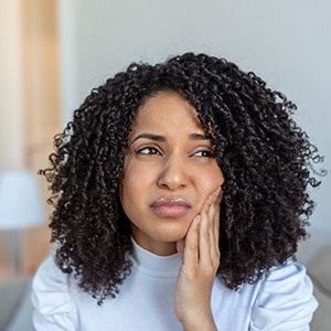 An unhappy woman experiencing a toothache at home