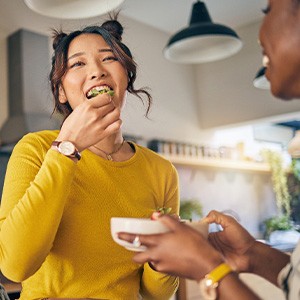 Woman in  yellow shirt enjoying salad with friends