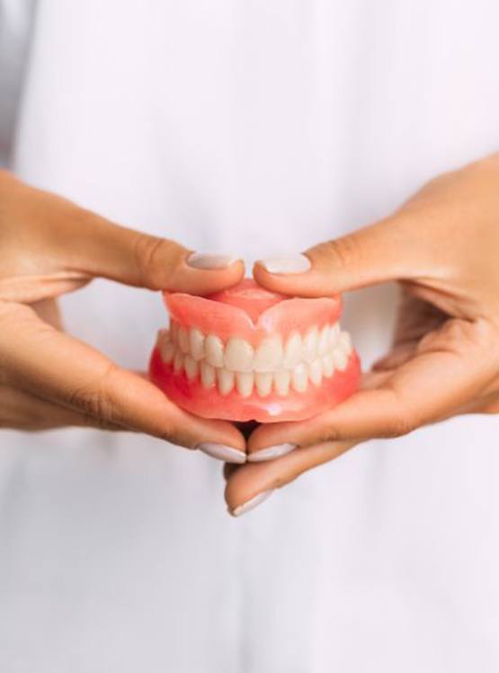 Lady presents viewer with dentures