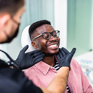 Dentist looking at patient's smile in treatment room