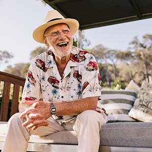 Closeup of man smiling outside on bench