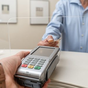 A man paying the cost of dental implants