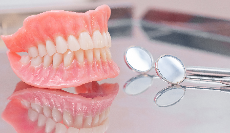 Dentures on table with dental mirrors